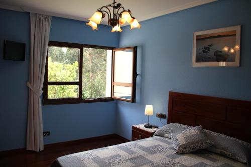 萨利纳斯Sierra Pulide Apartamentos的蓝色的卧室设有床和窗户