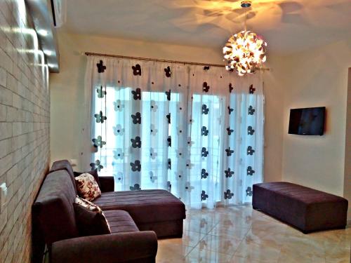 尼亚普拉莫斯Iro Apartment的带沙发和窗户的客厅