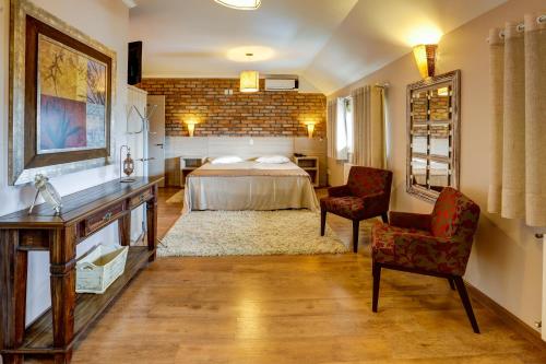 法罗皮利亚迪卡普里酒店的一间卧室配有一张床、两把椅子和一张桌子
