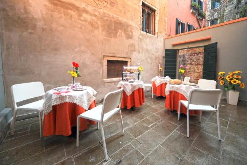 威尼斯里亚托梦幻住宿加早餐旅馆的一组桌椅,上面有鲜花