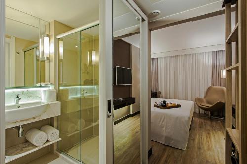 里约热内卢大西洋普莱姆酒店的浴室配有盥洗盆、淋浴和盥洗盆。