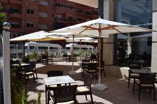马拉喀什特雷加Spa酒店的一个带桌椅和遮阳伞的户外庭院。