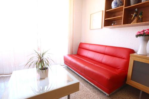 巴塞罗那博德塔公寓的客厅里一张红色的沙发,配有桌子
