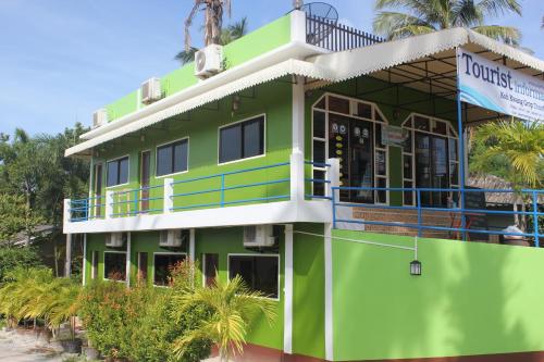 功孟海滩假日旅馆的带阳台和棕榈树的绿色建筑