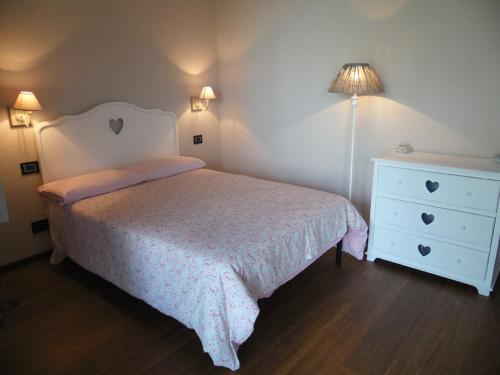 CastinoEremo Pace e Gioia的一间卧室配有床、梳妆台和灯