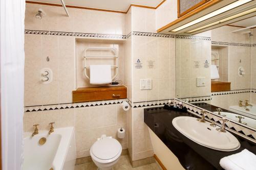 约克约克费尔菲尔德庄园美居酒店的浴室配有盥洗盆、卫生间和浴缸。