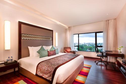 钦奈钦奈格兰德GRT酒店的酒店客房设有一张床、一张书桌和窗户。