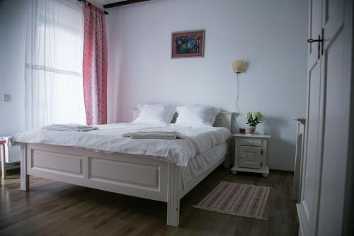 Budeasa MicăPensiunea Margareta的卧室配有白色的床和窗户。