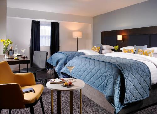 都柏林圣殿酒吧酒店的酒店客房,配有一张床、一张桌子和椅子
