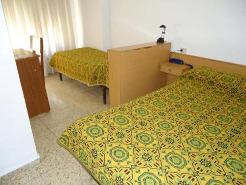 安道尔城因达罗餐厅旅馆的酒店客房带两张床以及黄色和绿色的床罩