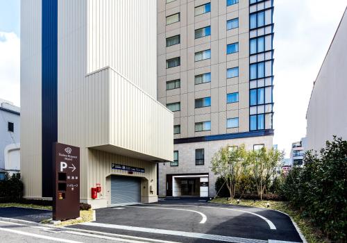 松山松山大和鲁内酒店的前面有停车标志的建筑