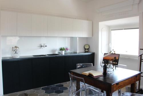 罗马La Rosa del Vaticano Luxury Apartment的厨房配有桌子和黑白厨房。