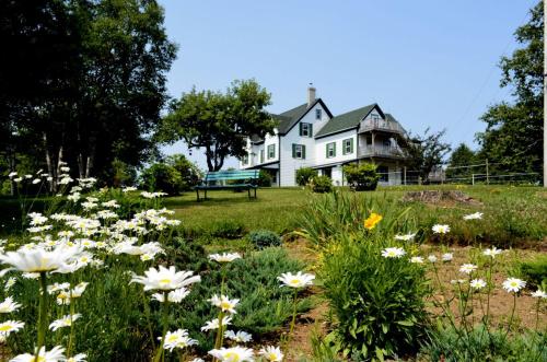 Deep BrookStill Point Lodge的一座白色的大房子,花田