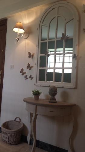 圣马丹勒博瓦雷公寓的一间设有镜子的房间和一张桌子,墙上有鸟儿