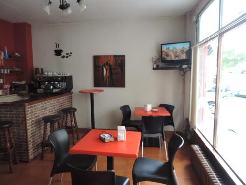 奥利瓦橙花酒店的一间餐厅,房间内设有红色的桌椅