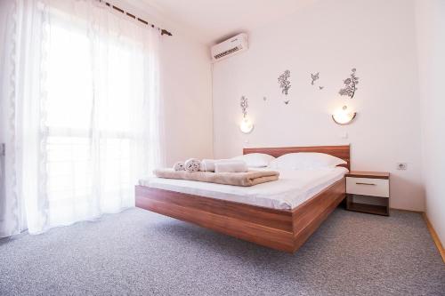 扎达尔玛丽亚膳食公寓的一间卧室配有一张大床和木制床头板