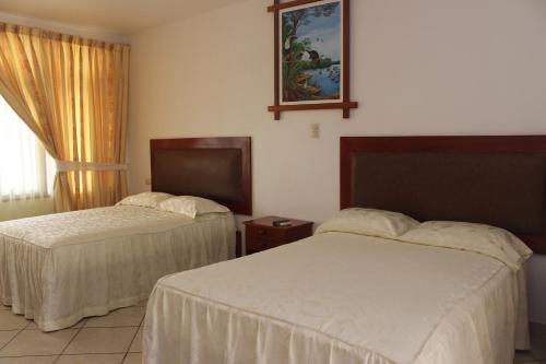 普卡尔帕普卡尔帕东方太阳酒店的酒店客房设有两张床和窗户。
