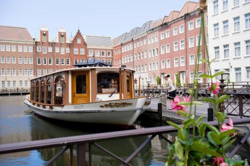 佐世保欧洲豪斯登堡酒店的船停靠在运河上,运河上有许多建筑