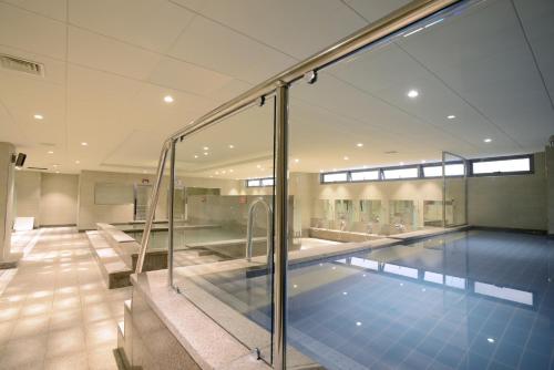 济州市阿斯塔尔酒店的一座带玻璃墙的建筑中的游泳池