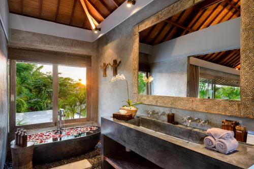 坎古伊帕内玛巴厘岛别墅的一间带大浴缸和大窗户的浴室