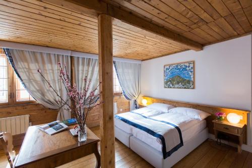 萨梅丹Kleos Hotel Bernina 1865的一间卧室设有一张床和木制天花板