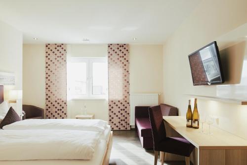 弗隆海姆Meyerhof - Weingut, Vinothek & Gästehaus的配有一张床和一张书桌的酒店客房