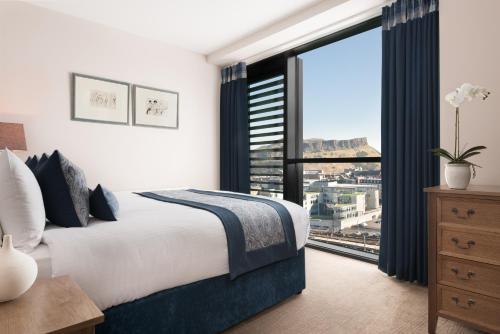 爱丁堡BDL王子大街套房酒店的一间卧室设有一张床和一个大窗户
