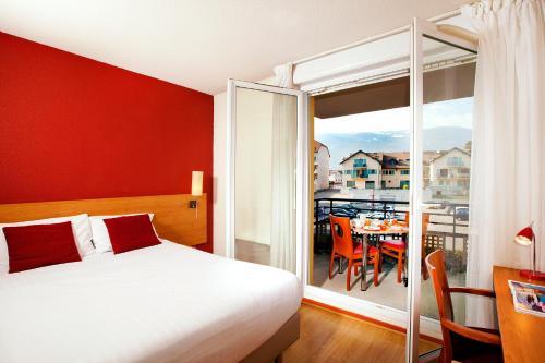 圣热尼普伊塞祖尔阿菲尔杰内夫圣杰尼酒店的一间卧室配有一张床,阳台配有桌子