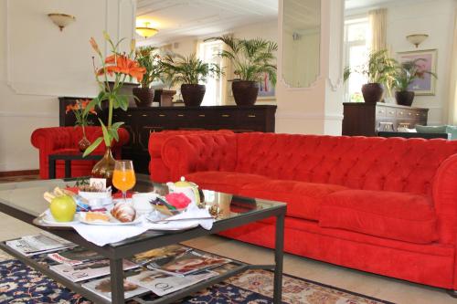 瓦拉泽瓦拉泽里维埃拉酒店的客厅里一张红色的沙发,配有茶几