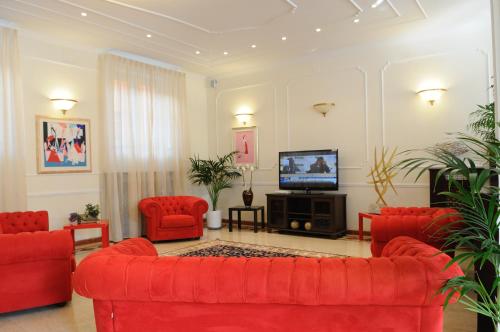 瓦拉泽瓦拉泽里维埃拉酒店的客厅配有红色家具和平面电视