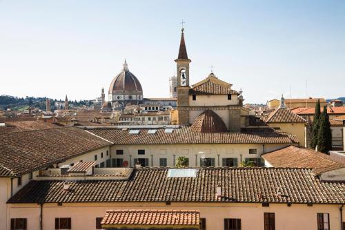 佛罗伦萨全景酒店的享有钟楼和屋顶的城市美景
