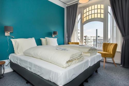 弗利辛恩弗利辛恩别墅酒店的蓝色墙壁客房的两张床