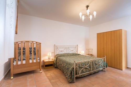 圣吉米纳诺拉魏格纳农家乐的一间卧室配有一张床和一个木制橱柜