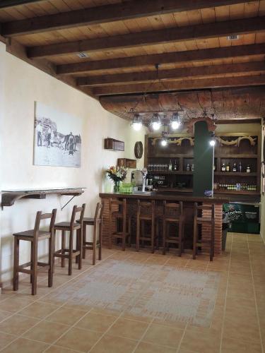 莱昂Albergue Santo Tomás de Canterbury的厨房设有带木凳的酒吧