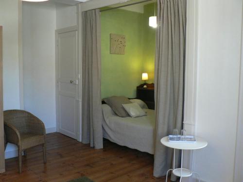 米格龙La Terrasse de la Grand'Rue - chambre d'hôtes -的一间卧室配有一张床、一张桌子和一面镜子