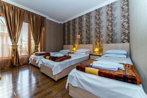 泰拉维HOTEL GUGLUX &WINE CELLAR的一间卧室设有三张床和窗户。
