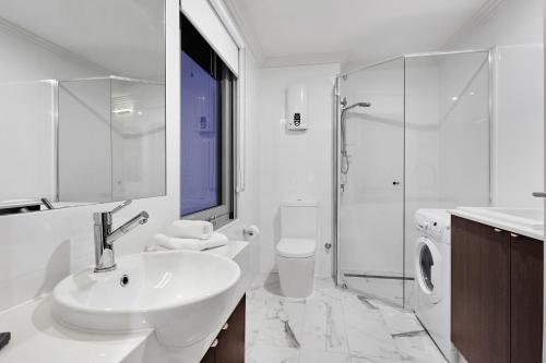 珀斯阿提卡酒店的白色的浴室设有水槽和淋浴。