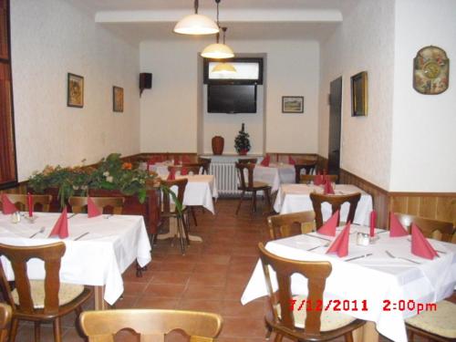 特里尔法伦沃尔夫酒店的餐厅配有桌椅和红色餐巾