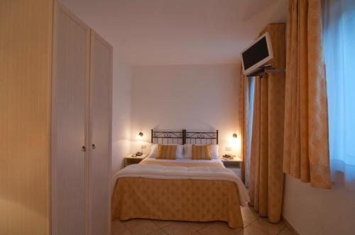 勒托阳尼席雷西雅酒店的卧室配有一张床,墙上配有电视。