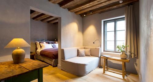萨尔茨堡维斯科鲁兹联排别墅酒店的一间卧室配有一张床、一张白色椅子和一张桌子
