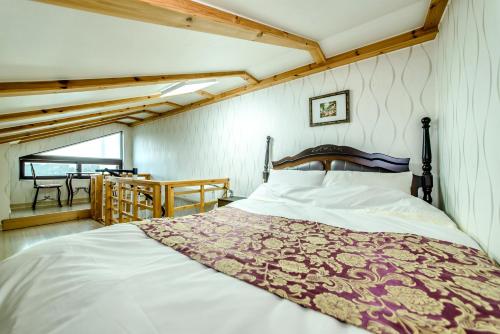 西归浦市济州色调度假屋的一间卧室配有一张带红白毯子的床