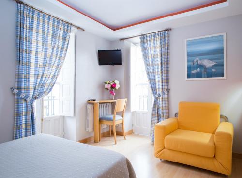 圣地亚哥－德孔波斯特拉萨尔萨巴邦特斯旅馆的一间卧室配有一张床、一把椅子和一张桌子