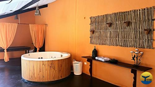 库穆鲁沙蒂巴Hotel Cumuruxatiba的一间带大浴缸和橙色墙壁的浴室