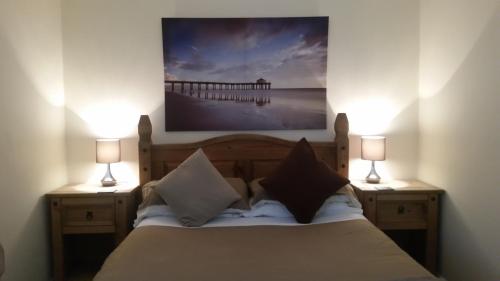 比德内尔Farne Lodge的一间卧室配有一张带两盏灯和码头的床。