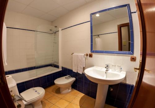 RusHotel Paraje La Lambra的一间带水槽、卫生间和镜子的浴室