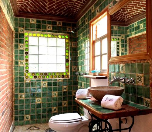 墨西哥城哈辛塔之家旅馆的绿色瓷砖浴室设有卫生间和水槽