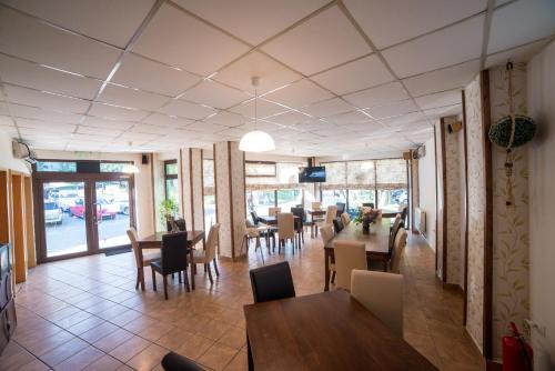 克拉约瓦Pensiunea Caramida Verde的用餐室设有桌椅和窗户。