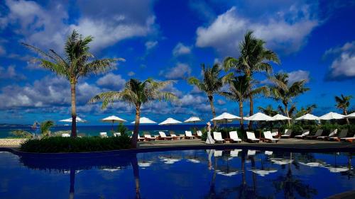 名户布森纳阳台酒店的棕榈树和遮阳伞度假村的游泳池