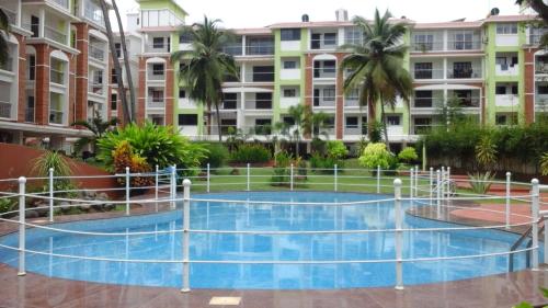 坎多林Premium -1BHK Apartment at Candolim Beach with Free Wifi的一座建筑物中央的游泳池