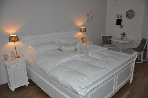 克洛彭堡White Cottage Garden的一张白色大床,配有白色床单和枕头